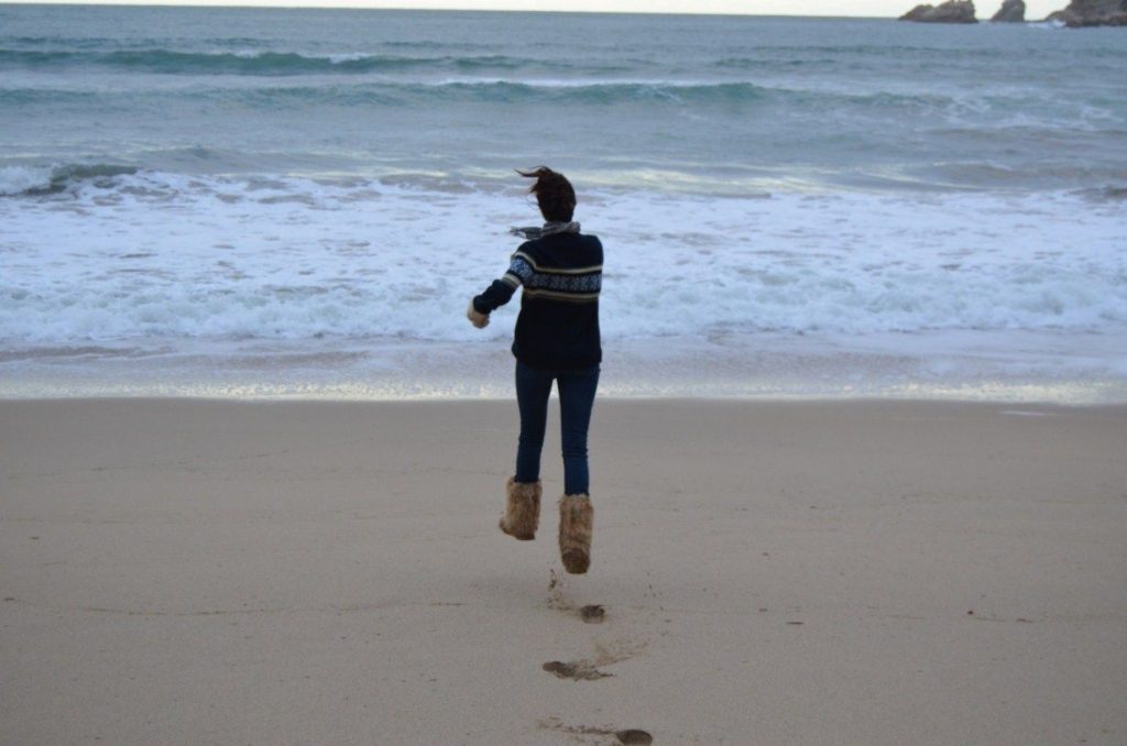 entusiasmo chica saltando playa