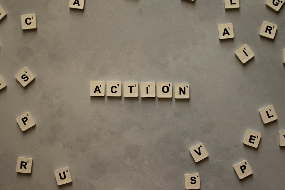 acción Flat lay of Scrabble tiles spelling 'Action' on a gray background, surrounded by random letters.